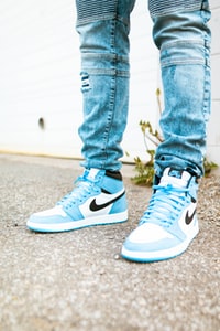 person in blue denim jeans and blue and white nike sneakers 穿着蓝色牛仔牛仔裤和蓝色和白色耐克运动鞋的人