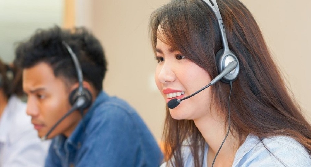 close up on asian call center woman work with diverse ethnic employee at operation monitor room for contact or talking with customer concept_edited